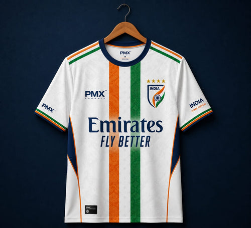 A white India national football team home jersey by PMX, featuring vertical orange, white, and green stripes down the center, with the Emirates Fly Better sponsor logo on the chest, displayed on a wooden hanger against a dark navy background.
